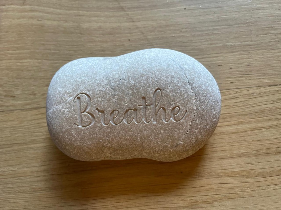 A stone engraved with the word Breathe