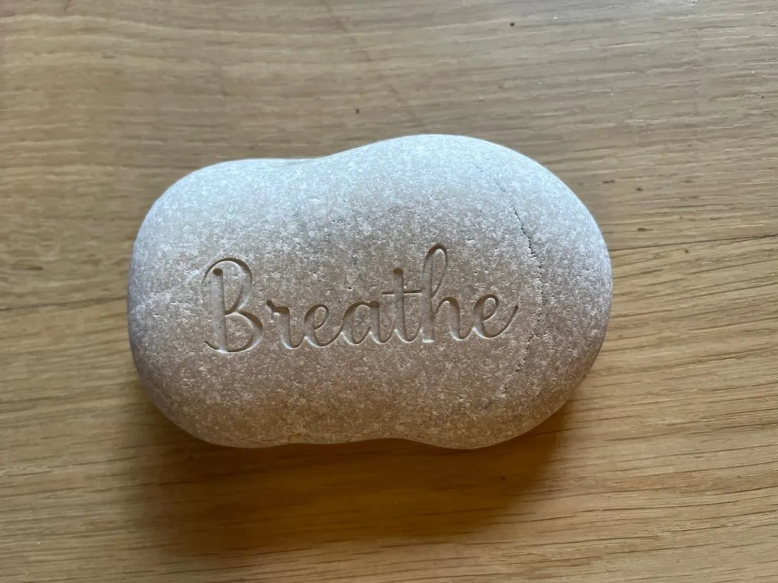 A stone engraved with the word Breathe